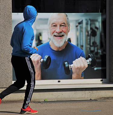 homme qui court devant une publicité de salle de sport